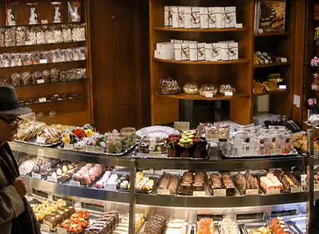Retail chocolate and dessert shop display with packaged sweets and gift boxes for branded in-store presentation