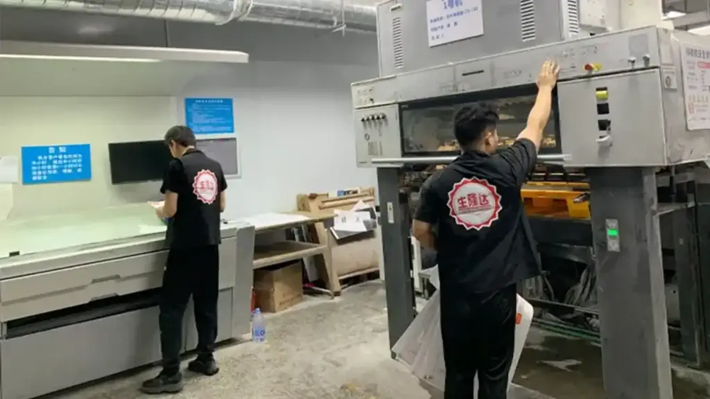 Packaging production team operating printing equipment for custom chocolate boxes, where setup requirements, box specifications and order quantity affect custom chocolate box cost and MOQ.